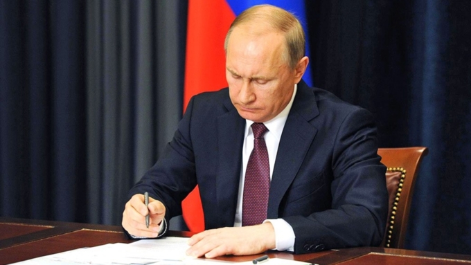 Президент России Владимир Владимирович Путин подписывает указ о внесении изменений в Федеральный Закон